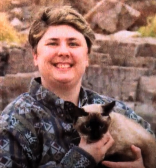 Darlene VanderGiesen holding a black and cream Siamese cat