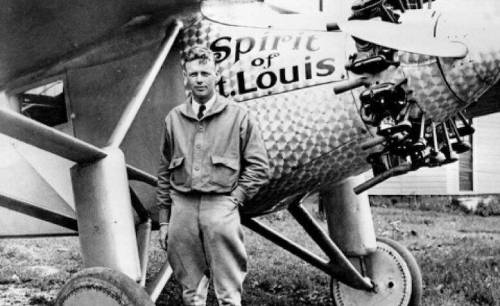 Charles Lindbergh at 25 years of age standing in front of his airplane